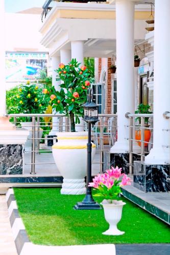 a group of flowers in vases on a porch at 5 Star Villa Hotel in Accra