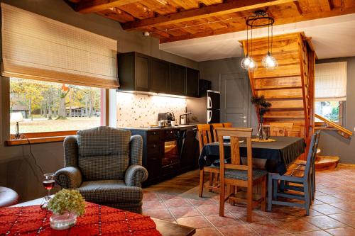 een keuken en woonkamer met een tafel en stoelen bij Atpūtas komplekss Usmas Meķi in Renda