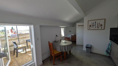 una stanza con tavolo e sedie e una sala da pranzo di Studio avec balcon a Uzès