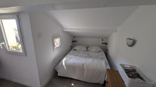 Studio avec balcon في ازيس: سرير صغير في غرفة صغيرة بها نافذة