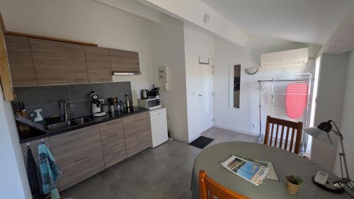 una cucina con un tavolo e una cucina con un lavello di Studio avec balcon a Uzès