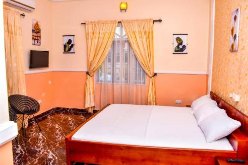 a bedroom with a large bed and a window at 5 Star Villa Hotel in Accra