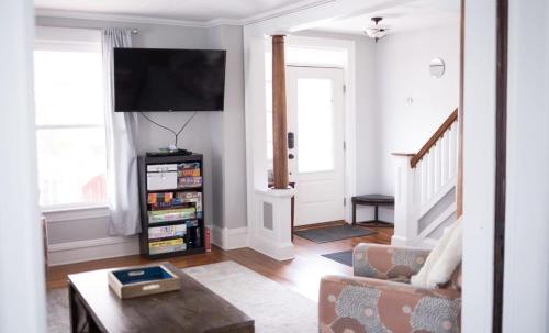 a living room with a couch and a flat screen tv at Cityside Escape Spacious with Game Room & Fire Pit in Geneva