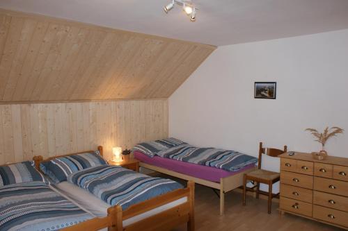 a bedroom with two beds and a dresser at Gasthaus Waldheim in Fürstenaubruck