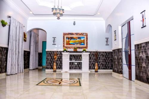 a living room with a fireplace and a painting on the wall at 5 Star Villa Hotel in Accra