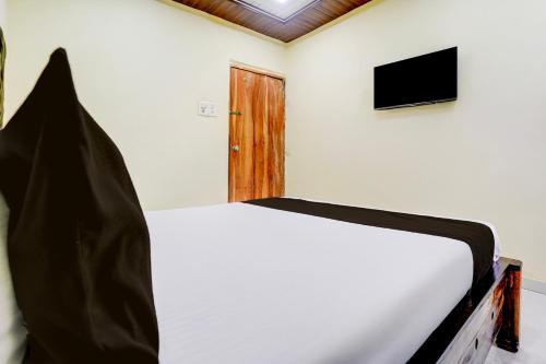 a bedroom with a bed and a television on a wall at Hotel O Royal Inn in Mumbai