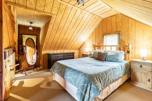 una camera da letto con un letto in una stanza con pareti in legno di Martin Springs Cabin a South Pittsburg