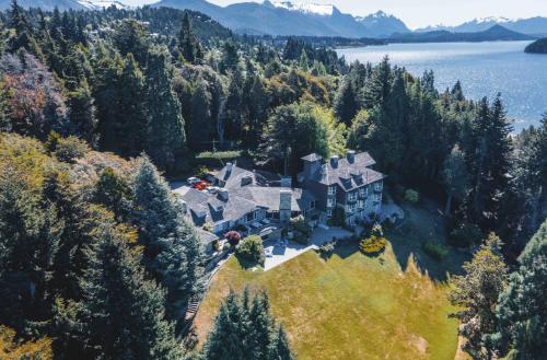 an aerial view of a house on a hill next to the water at La Cascada Casa Patagónica by DON in San Carlos de Bariloche