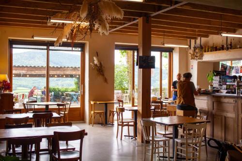 un restaurante con mesas y sillas y vistas a un puente en Auberge de Boffres, en Boffres