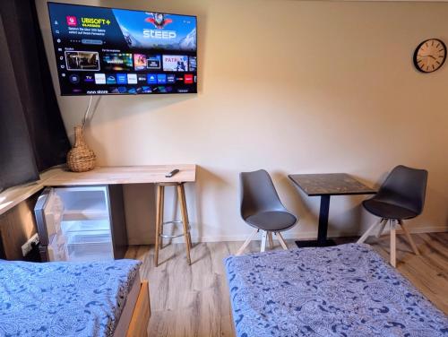 a room with two chairs and a desk and a tv at Pension Glückauf in Sondershausen