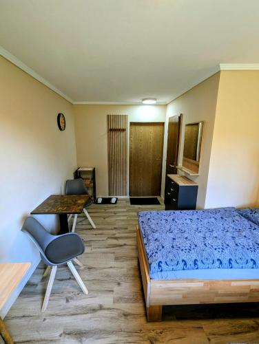 a bedroom with a bed and a table and chairs at Pension Glückauf in Sondershausen
