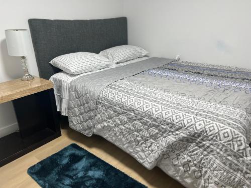 a bed with a comforter and pillows on it at Bliss Haven in Winnipeg