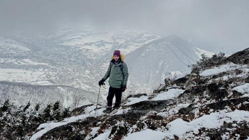 a woman standing on top of a snow covered mountain at Old farm in Ijevan