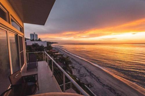 a view of the beach at sunset from a balcony at El Penthouse Suite in La Chumicosa