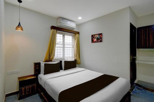 a bedroom with a bed and a window at Hotel O The Pramaan in Kukatpalli