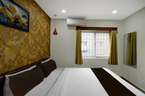 a bedroom with a bed and a window at Hotel O The Pramaan in Kukatpalli