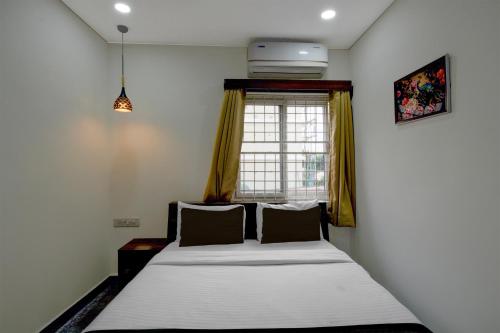 a bed in a room with a window at Hotel O The Pramaan in Kukatpalli