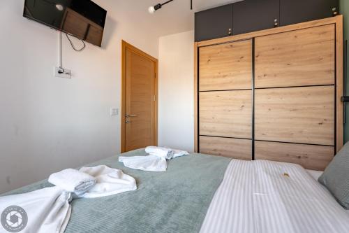 ズラティボールにあるApartment 5A bed & breakfast Zlatiborのベッドルーム1室(ベッド1台にタオル2枚付)