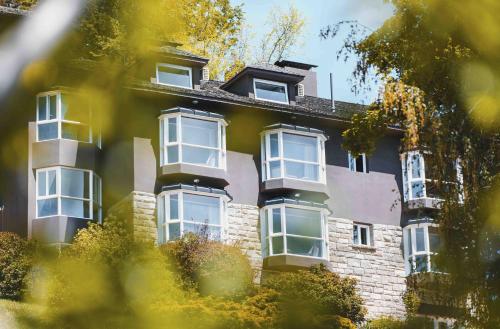 a large brick building with white windows at La Cascada Casa Patagónica by DON in San Carlos de Bariloche