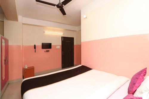 a bedroom with a bed and a tv on the wall at Hotel O Prabha Palace Lodge in Guwahati