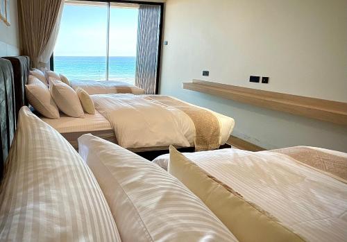 four beds in a room with a view of the ocean at Fins Dream Villas in Fins
