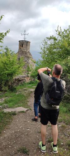 a man taking a picture of a cross on a hill at Old farm in Ijevan