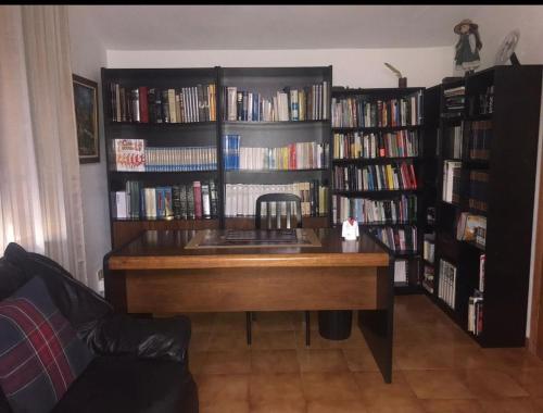 a library with a desk and book shelves filled with books at El Pajar casa campestre in El Pinar del Hierro