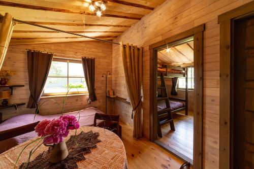 een kamer met een tafel met een vaas met bloemen erop bij Atpūtas komplekss Usmas Meķi in Renda