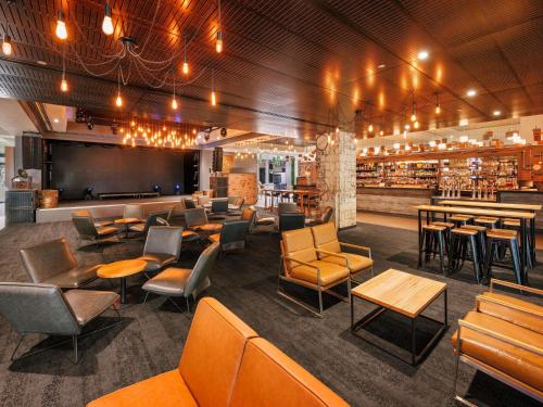 a restaurant with chairs and tables and a bar at Pullman Reef Hotel Casino in Cairns