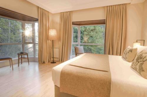 a bedroom with a bed and a large window at La Cascada Casa Patagónica by DON in San Carlos de Bariloche