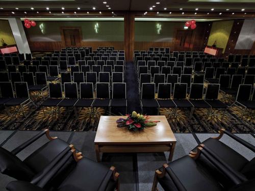 an empty auditorium with chairs and a table with flowers on it at Pullman Reef Hotel Casino in Cairns
