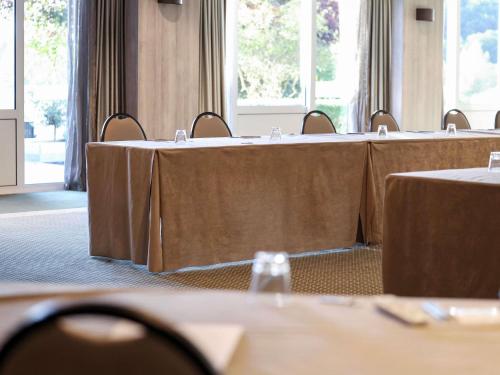 a row of tables in a conference room with tablesktop at Mercure Luxembourg Kikuoka Golf & Spa in Canach