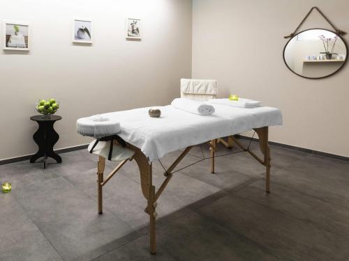a table with a white blanket on it in a room at Mercure Luxembourg Kikuoka Golf & Spa in Canach