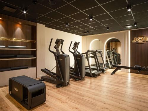 a gym with a row of treadmills and a tv at Mercure Saint-Lary in Saint-Lary-Soulan