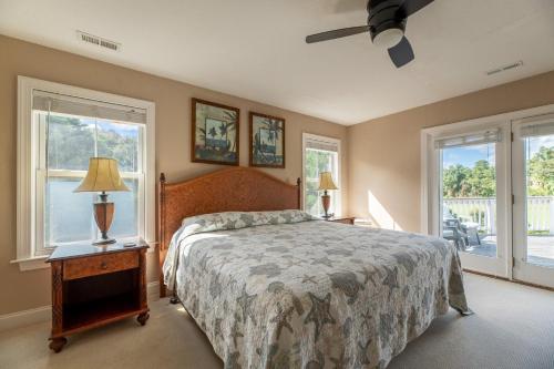 a bedroom with a bed and two windows at Show Boat in Kitty Hawk