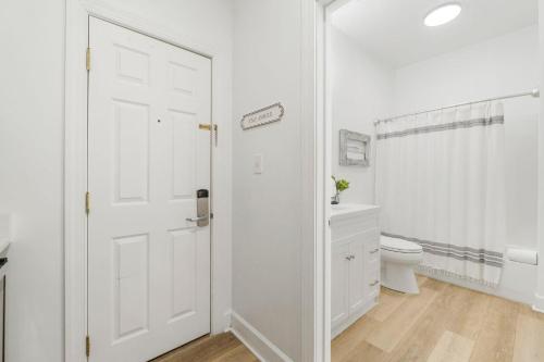 Un baño blanco con inodoro y puerta blanca. en Village of SoWal B257, en Rosemary Beach