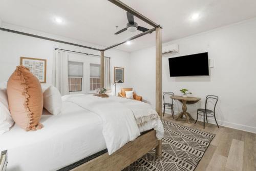 Un dormitorio blanco con una cama grande y un televisor de pantalla plana. en Village of SoWal B257, en Rosemary Beach