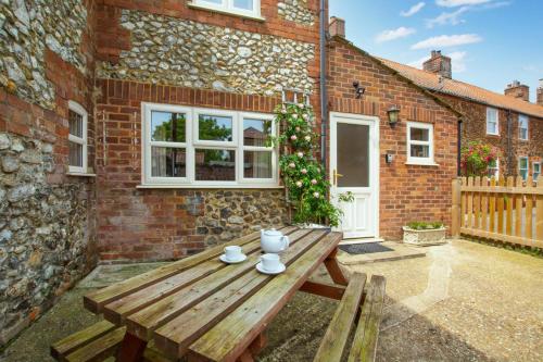 a wooden picnic table in front of a brick building at 2 Carr Terrace in Docking