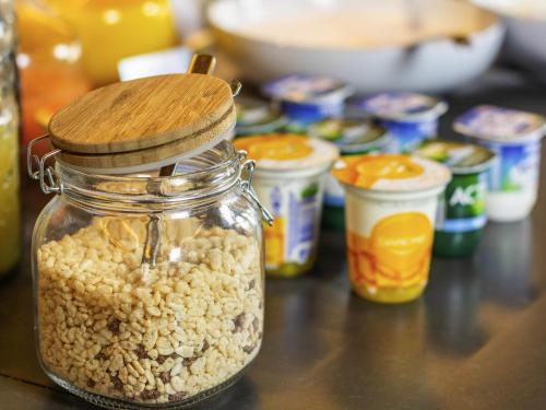 a jar of peanuts sitting on a table with other foods at Mercure Hotel Dortmund City in Dortmund