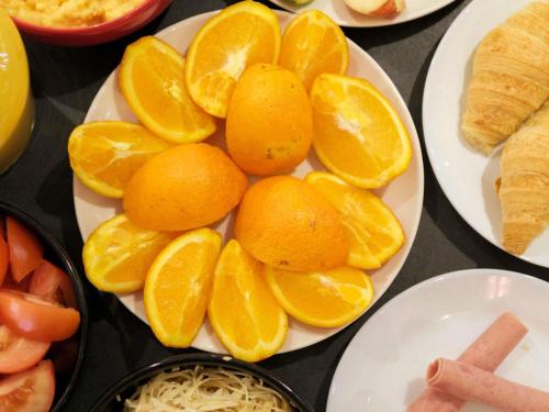 a plate of oranges and other fruits on a table at ibis Strasbourg Sud La Vigie in Ostwald
