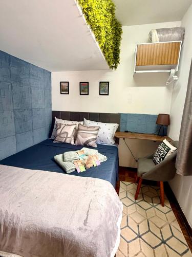 a bedroom with a bed and a desk and a chair at Aconchego em congonhas- CGH in Sao Paulo