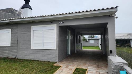 Una entrada de garaje a una casa con puertas blancas. en Casa de Férias, en Capão da Canoa
