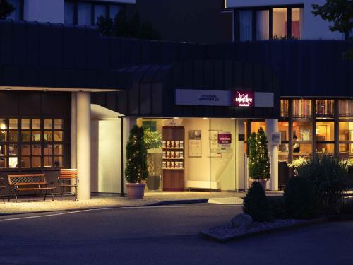 a store front at night with a sign on the door at Mercure Hotel am Messeplatz Offenburg in Offenburg