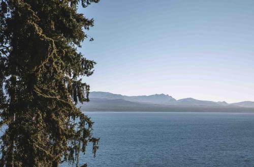 a view of the water with mountains in the background at La Cascada Casa Patagónica by DON in San Carlos de Bariloche