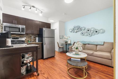 a kitchen and living room with a stainless steel refrigerator at The Pearl Beachside Apartments on Hollywood Beach in Hollywood
