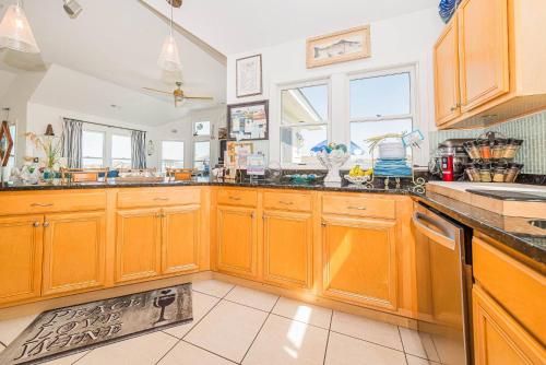 a kitchen with wooden cabinets and a sink at Simple Gifts by the Sea in Duck
