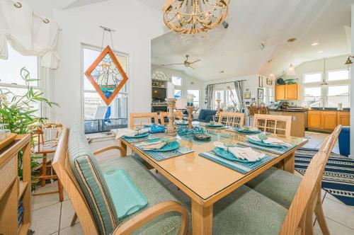 a dining room and living room with a table and chairs at Simple Gifts by the Sea in Duck