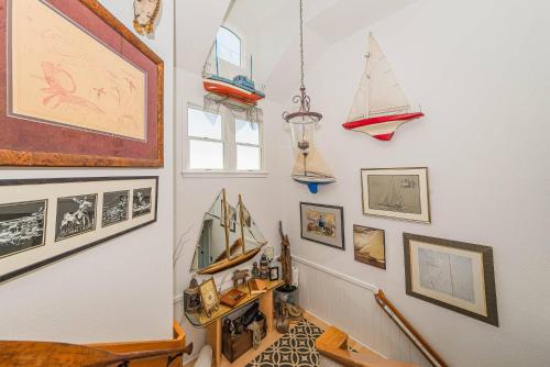 a hallway with a bunch of pictures on the wall at Simple Gifts by the Sea in Duck