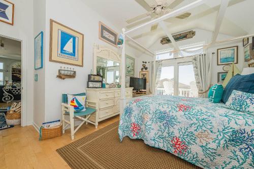 a bedroom with a bed and a mirror at Simple Gifts by the Sea in Duck