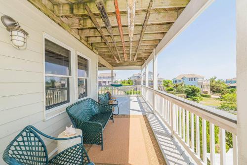 a porch with two chairs and a view of the ocean at Simple Gifts by the Sea in Duck